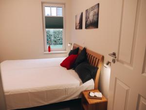 伯尔格伦德-雷特维施Ferienwohnungen Parkstraße的一间卧室配有一张带白色床单的床和一扇窗户。