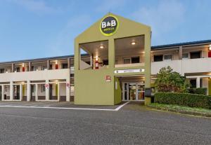 坎佩尔B&B HOTEL Quimper Nord Douarnenez的大楼前的一个空停车位