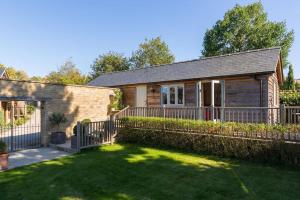 查尔伯里Charming Cottage surrounded by Idyllic garden in peaceful location in central Charlbury的院子前有围栏的房子