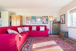 查尔伯里Charming Cottage surrounded by Idyllic garden in peaceful location in central Charlbury的客厅配有红色沙发和地毯。