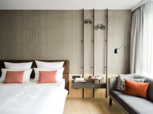 明斯特ATLANTIC Hotel Münster的一间卧室配有一张床和一张沙发
