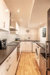 布莱顿霍夫Brighton & Hove Beach - group or family fun的厨房配有白色橱柜、洗衣机和烘干机