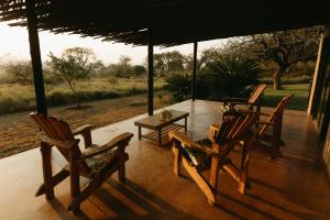 MkuzeSensiri Plains Safari Lodge的门廊上的一组椅子和一张桌子