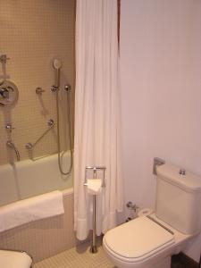 德累斯顿艾克城堡酒店的浴室配有卫生间和带浴缸的淋浴。