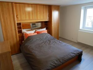 EpfigAppartement entier dans cour intérieure的卧室设有一张带木墙和窗户的大床