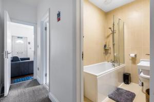 伦敦Spacious 2 bed Apartment with FREE PARKING for 2 cars and underground station Zone 2 for quick access to Central London up to 8 guests的带浴缸、卫生间和盥洗盆的浴室