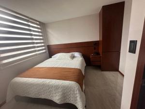 洛哈Hotel Caluva的一间小卧室,配有床和窗户