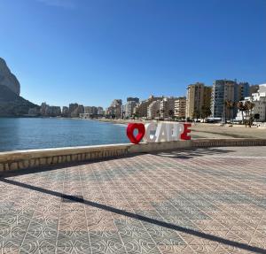 卡尔佩Alojamento entero - playa de la fossa的海滩旁的咖啡馆读书的标语