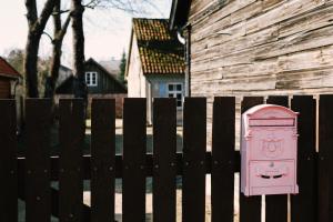 库尔迪加Kalnciema kvartāla Kuldīgas rezidence的房屋旁栅栏上的粉红色门