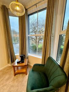 贝图瑟科伊德古易迪尔酒店的客厅设有绿椅和窗户