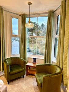 贝图瑟科伊德古易迪尔酒店的客厅配有两把椅子和窗户