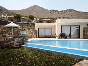伊罗达Elounda Palm Hotel & Suites的一座带游泳池和房子的别墅