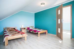 厄尔科Agroturystyka Golubie的一间设有两张床的客房,拥有蓝色的墙壁