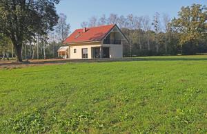 上拉德戈纳Hiša Štolc的一座白色的房子,在田野上有一个红色的屋顶