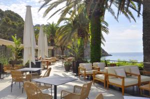 滨海托萨Zel Costa Brava的一个带桌椅的庭院和大海