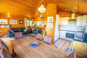 BrooklandFive Waterings - Luxury Lodge的厨房和带木制天花板的客厅