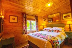 BrooklandRainbow Petty - Pine lodge - Kent countryside的小木屋内一间卧室,配有一张床