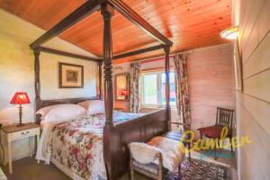 BrooklandTore Petty - Romantic lodge - spa bath and sauna的一间卧室,卧室内配有一张天蓬床
