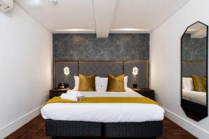 开普敦Cape Diamond Boutique Hotel的一间卧室配有一张带黄色枕头的大床