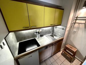 里蒙纽耶Résidence Oisans - 2 Pièces pour 6 Personnes 824的一间设有黄色橱柜和水槽的小厨房
