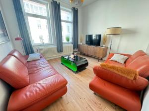 不来梅港Gemütliche Retro Wohnung的客厅配有两张真皮沙发和一台电视机