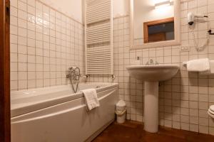 圣马尔蒂诺博纳尔贝尔戈穆塞拉酒庄乡村民宿的带浴缸和盥洗盆的浴室