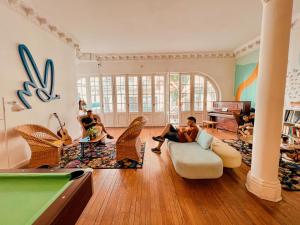 蒙得维的亚Viajero Montevideo Hostel的两人坐在客厅里,客厅里设有台球桌