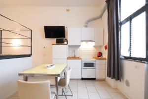 米兰PrimoPiano - Acerenza Flats的小厨房配有白色橱柜和桌子