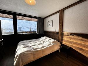 里蒙纽耶Résidence Aravis - 2 Pièces pour 4 Personnes 444的一间卧室设有一张床和两个窗户。