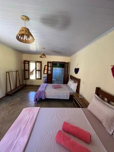 卡瓦坎特Pousada Varanda da Serra的一间卧室配有两张带粉红色床单的床