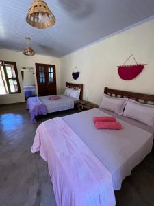 卡瓦坎特Pousada Varanda da Serra的一间卧室配有两张带粉红色床单的床