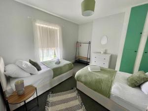 Large 3 Bed House - Awsworth - J26 M1 - Ideal for Contractors or Families - Sleeps - 6的一间卧室设有两张床、一张桌子和一个窗口
