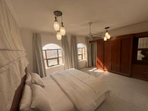 塞拉莱RED-22- ALSALAM suites的卧室设有一张白色大床和两个窗户。