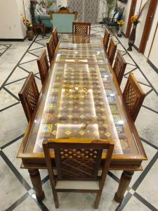 阿格拉Gupta Vilas - A Boutique Homestay的一张长木桌子,四周摆放着椅子