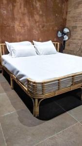 希莫加Earthy - Vintage的一张带白色床单和枕头的木床