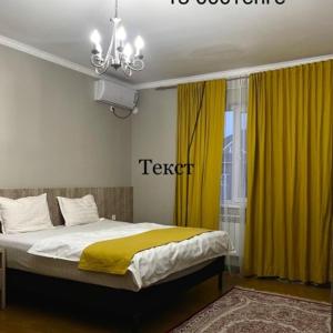 奇姆肯特MINI HOTEL COMFORT的一间卧室配有黄色窗帘的床