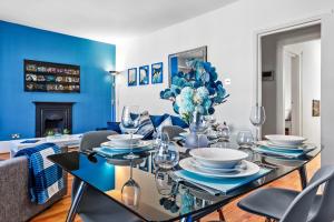 伦敦Blue Themed Luxury 1 Bedroom Balcony Flat, With Double Sofa Bed and Fast Wifi! Accommodates up to 6 Guests! Hyde Park!的一间拥有蓝色墙壁和桌椅的用餐室
