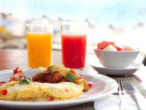 布里奇敦椰子园海滩酒店的包括鸡蛋和一碗水果的早餐食品