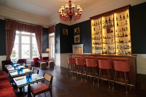 彼索普斯托福唐霍尔酒店的餐厅设有红色椅子和酒吧
