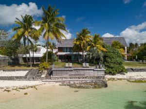 贝尔马尔Villa Rubis by muse villas的棕榈树海滩上的房子