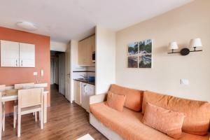 戛纳Résidence Cannes Villa Francia - maeva Home - Appartement 2 pièces 5 perso 634的一间带橙色沙发的客厅和一间厨房