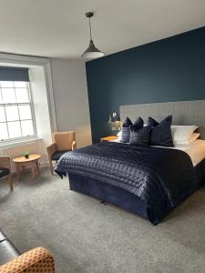 彭布罗克郡THE LORD NELSON HOTEL的一间卧室设有一张蓝色墙壁的大床