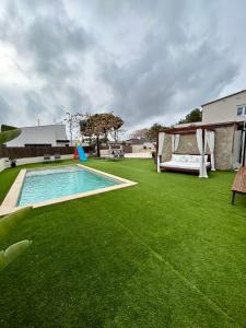 比利亚努埃瓦-赫尔特鲁Acogedora casa con piscina y 3 dormitorios的后院设有游泳池和绿草