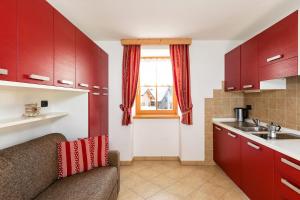 利维纳隆戈德尔科Cesa Raggio di Sole Monolocale的一间带红色橱柜和水槽的厨房