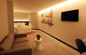 阿布扎比AUHotel - Zayed International Airport的客厅配有沙发和1张床