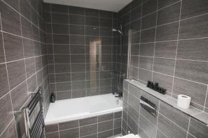 利明顿温泉The Windsor Club Apartment的带浴缸和卫生间的浴室。