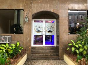 尼泰罗伊尼泰罗伊培亚格兰德酒店的一座带楼梯和植物的建筑的前门