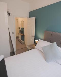 利明顿温泉The Windsor Club Apartment的卧室设有白色的床和走廊