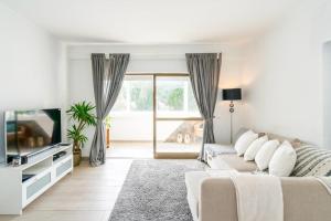 奎特里拉Spacious 1 bed in Vilamoura, Fast Wifi & Pool的带沙发和电视的白色客厅