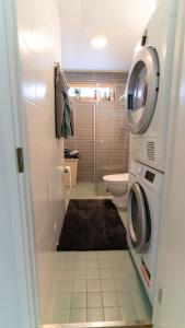 耶尔文佩Spacious 68m2 apartment with fabulous forest view的浴室设有洗衣机和烘干机,位于厕所旁